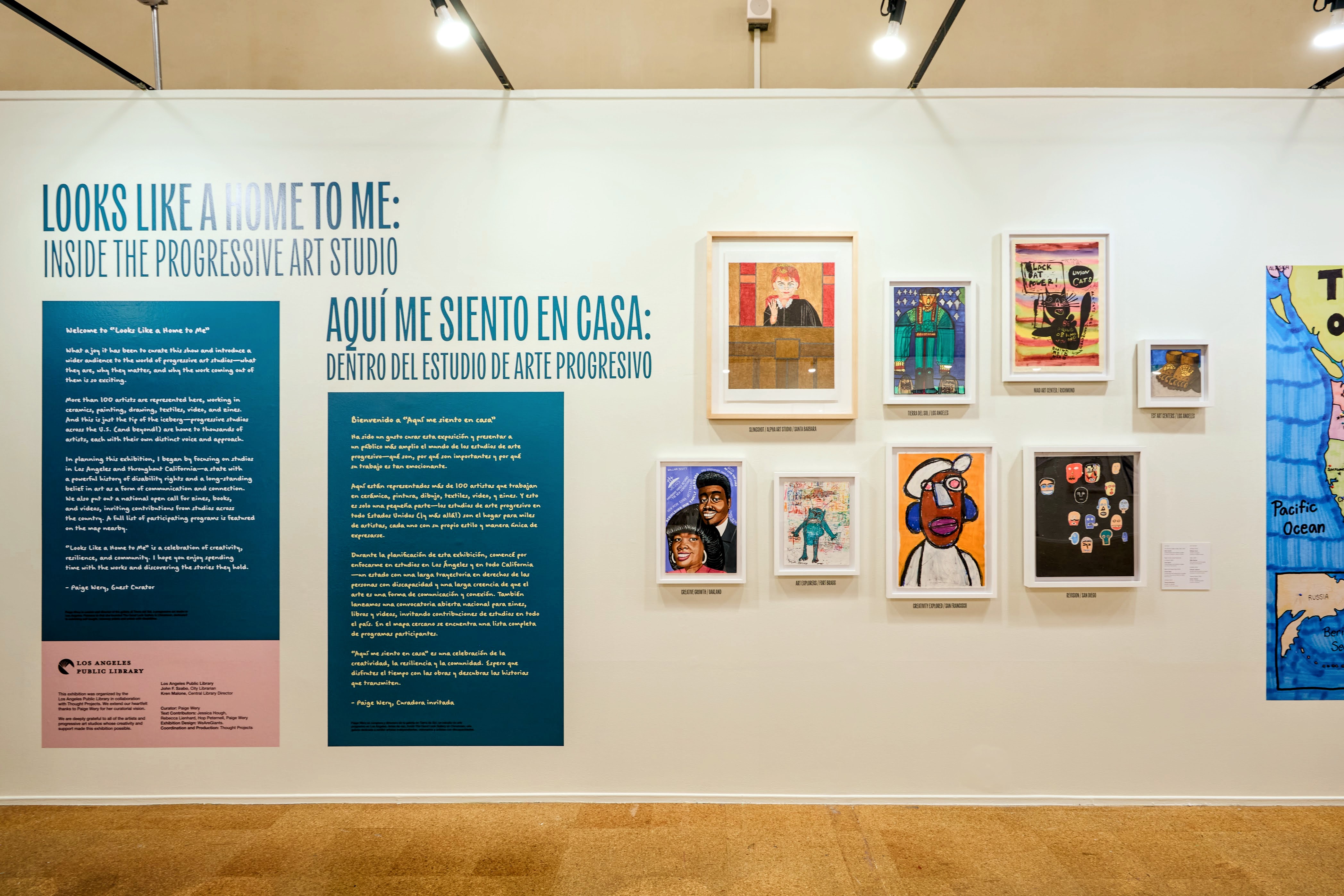 Two visitors engage with exhibition text panels at Looks Like a Home to Me